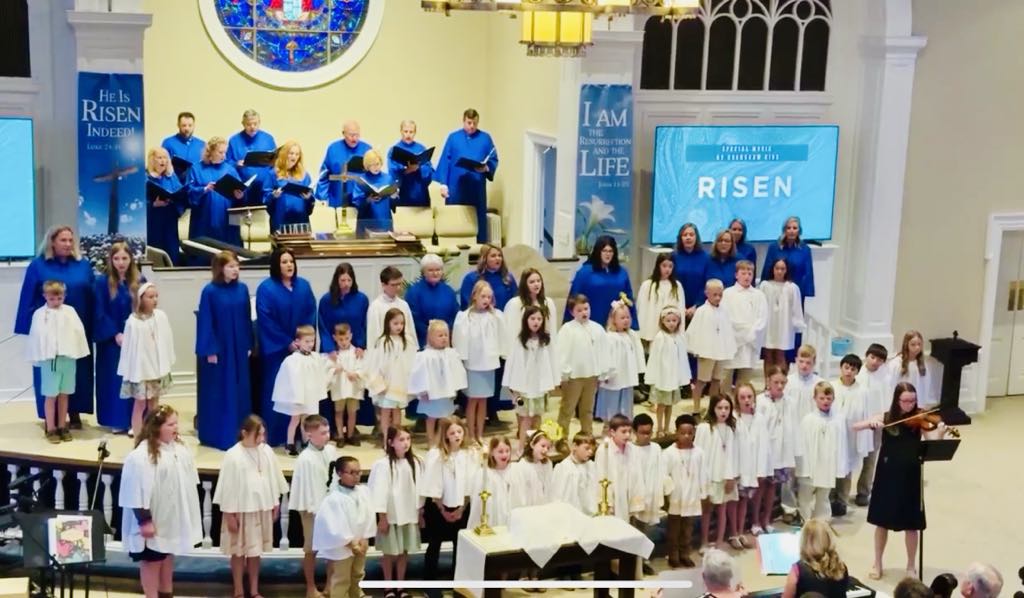 choir of children in white, and adults in blue robes