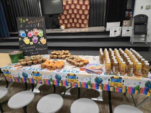 Muffins and juice on table with a colorful sign